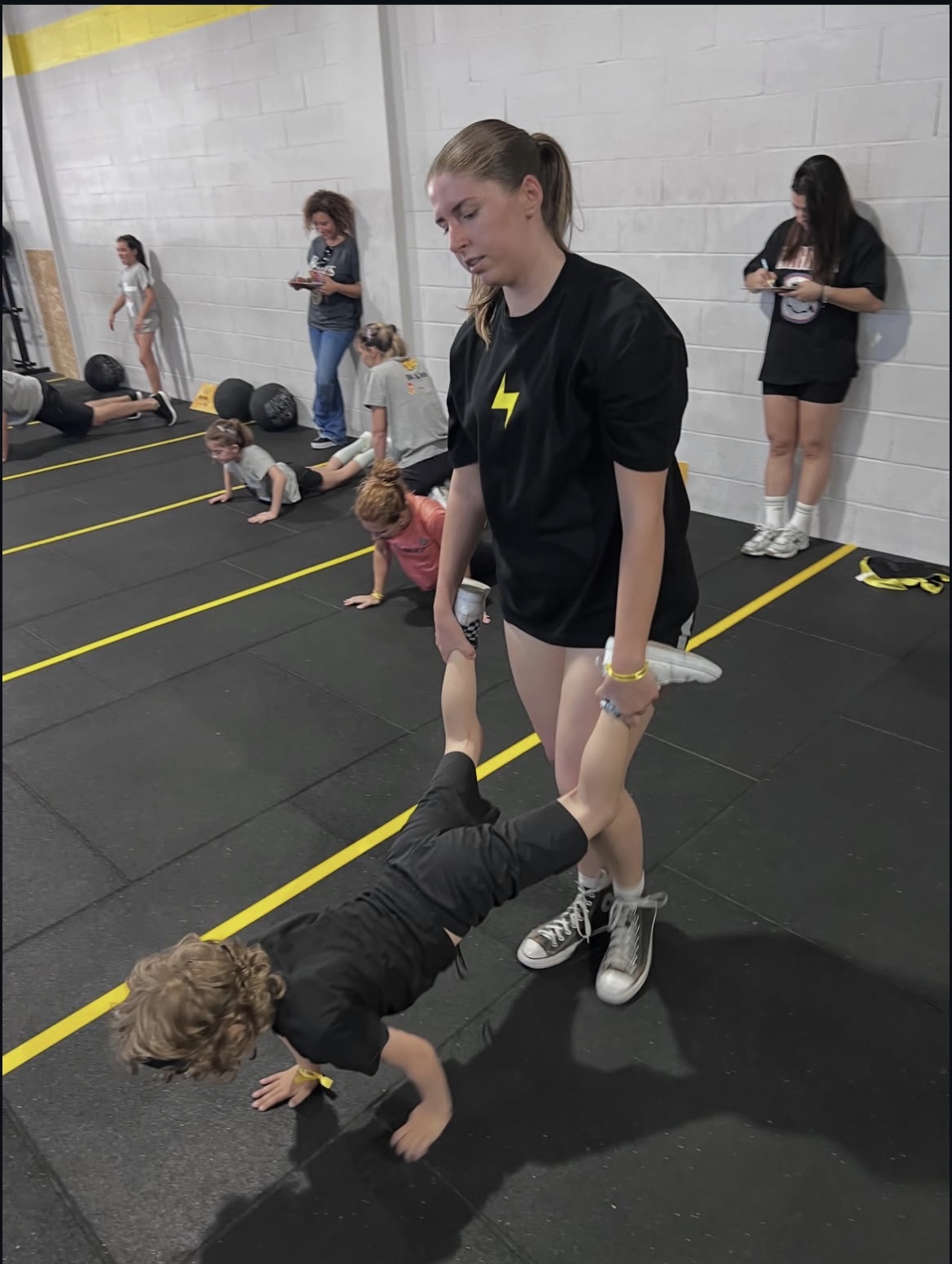 Criança e treinadora num desafio físico do Big & Little Thunders